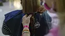 Iliana Maluenga memotong rambutnya untuk disumbangkan sebagai pembuatan wig bagi pasien kanker dalam acara Bulan Peduli Kanker Payudara di sebuah mal di Caracas, Venezuela, Sabtu (16/10/2021). Bulan Peduli Kanker Payudara diperingati diseluruh dunia setiap bulan Oktober. (AP Photo/Ariana Cubillos)