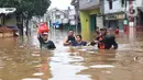 Warga melintasi banjir di perumahan Ciledug Indah, Tangerang, Rabu (1/1/2020). Banjir setinggi dada orang dewasa terjadi akibat meluapnya kali angke. (Liputan6.com/Angga Yuniar)