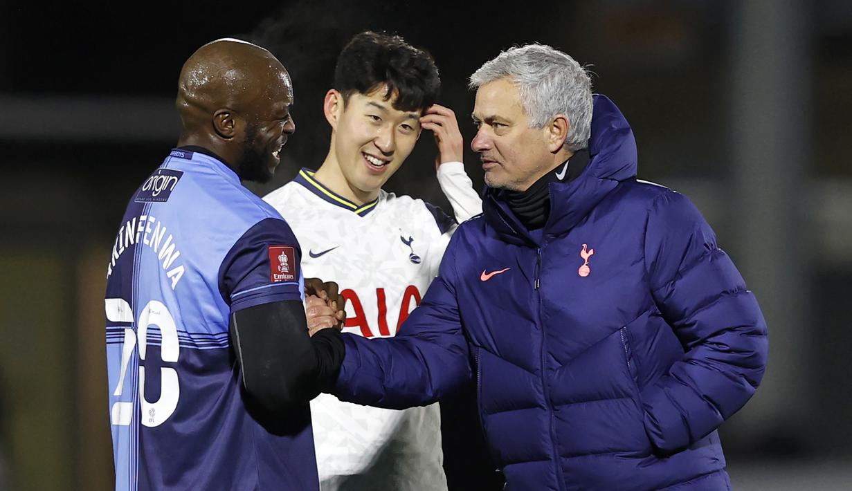 Striker Wycombe Wanderers, Adebayo Akinfenwa (kiri) menyapa manajer tim Tottenham Hotspur, Jose Mourinho usai laga babak keenpat Piala FA 2020/21 di Adams Park Stadium, Senin (25/1/2021). Wycombe Wanderers kalah 1-4 dari Tottenham Hotspur. (AFP/Adrian Dennis)