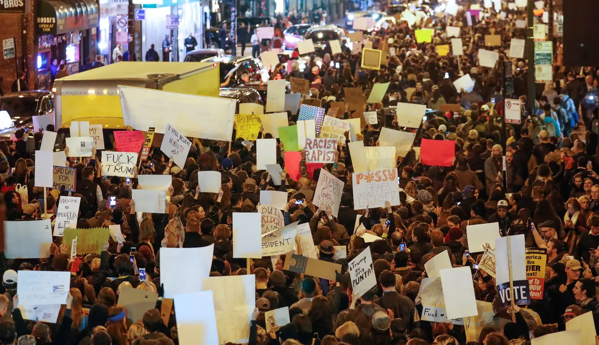 Pengunjuk rasa membawa berbagai poster turun ke jalan memprotes kemenangan Trump dalam pemilihan Presiden AS, di Chicago, Illinois, Rabu (9/11). Mereka meneriakkan yel-yel bahwa Donald Trump "bukan presiden kami." (REUTERS/Kamil Krzacznski)