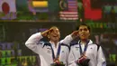 Nitya Krishinda (kanan) dan Gresya Polii menyanyi Indonesia Raya ketika pengibaran bendera merah putih di Gyeyang Gymnasium, Incheon, Korsel, (27/9). (ANTARA FOTO/SAPTONO)