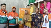 Business Coach BTPN Syariah area Riau, Fauzan Ridha memberikan cinderamata kepada UMKM Ultra Mikro kerupuk Kuansing di Kelurahan Air Dingin, Kota Pekanbaru. (Liputan6.com/Dicky Agung Prihanto)