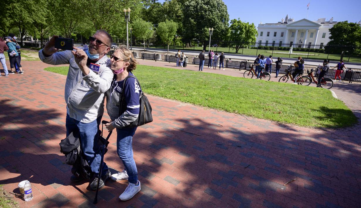 Turis dan warga mengunjungi Lafayette Square dekat Gedung Putih di Washington, DC, pada Selasa (10/5/2021). Lafayette Square dibuka kembali untuk pejalan kaki hampir setahun setelah daerah itu dipagari ketika demonstrasi semakin besar sebagai tanggapan atas kematian George Floyd. (Eric BARADAT/AFP)