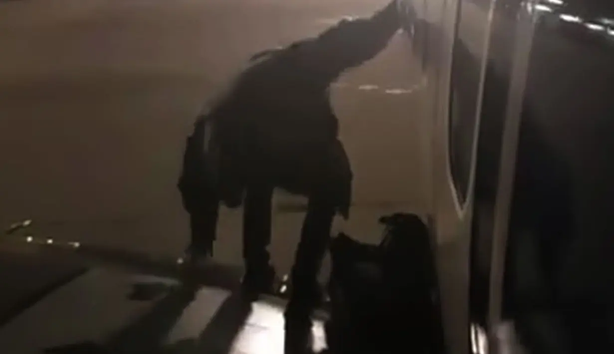 Seorang penumpang maskapai Ryanair keluar lewat pintu darurat di sayap pesawat di Bandara Malaga, Spanyol, Rabu (3/1). Tindakan pria ini menjadi viral ketika penumpang lain, Fernando del Vall, merekamnya dan viral di Facebook. (Fernando del Valle via AP)