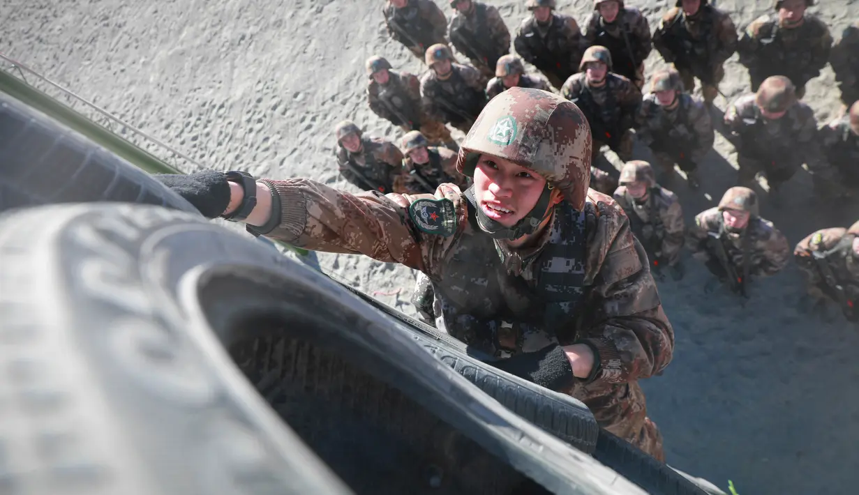 Aksi prajurit Tentara Pembebasan Rakyat (PLA) memancat ban truk dalam latihan militer di Pegunungan Pamir, Kashgar, wilayah Xinjiang, barat laut China (4/1/2021). (AFP/STR)