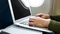 Ilustrasi laptop dalam pesawat. (iStock)