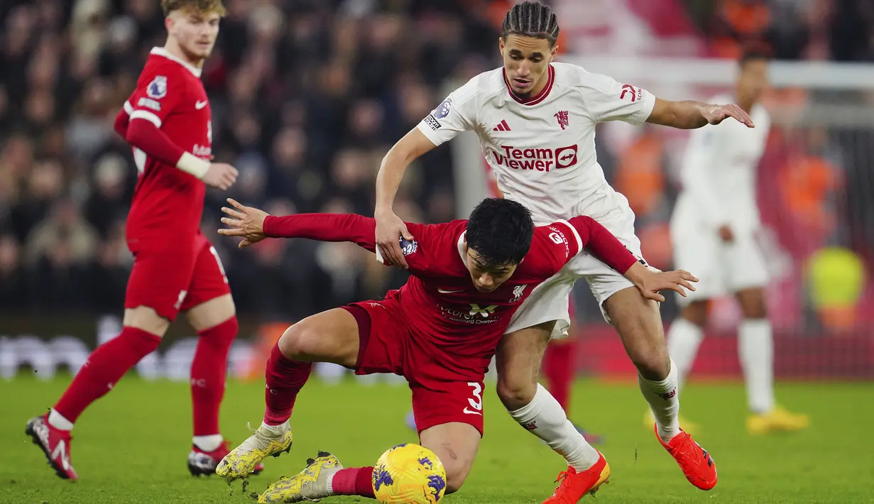 Pemain Manchester United, Hannibal Mejbri (kanan) berebut bola dengan pemain Liverpool, Wataru Endo pada laga lanjutan Liga Inggris 2023/2024 di Anfield, Liverpool, Inggris, Rabu (18/12/2023) dini hari WIB. (AP Photo/Jon Super)