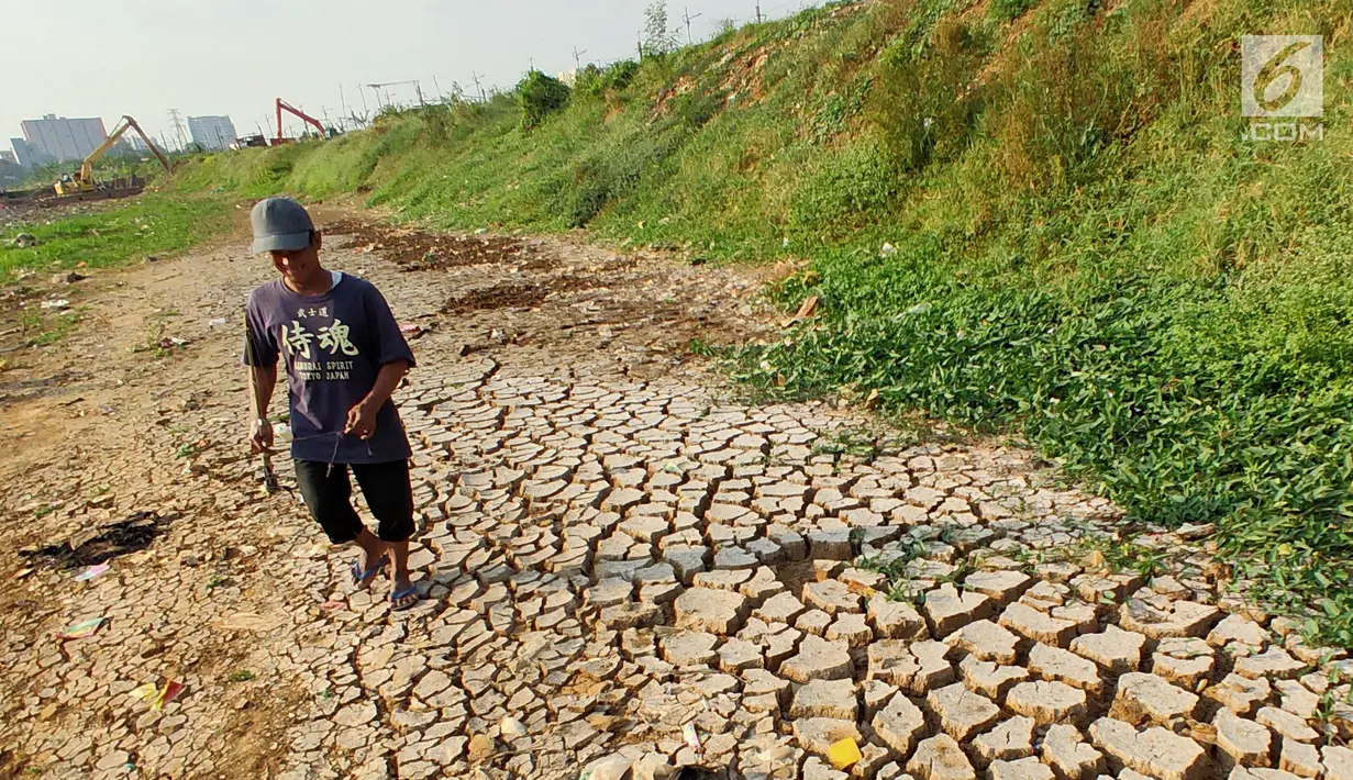 Warga bersiap memancing di sekitar Kanal Banjir Barat (KBB) yang mengalami kekeringan di kawasan Tanah Abang, Jakarta, Jumat (12/7/2019). Musim kemarau yang terjadi di Ibu Kota menyebabkan debit air di KBB berkurang sehingga menimbulkan keretakan tanah di sekitarnya. (Liputan6.com/Immanuel Antonius)