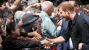 Pangeran Harry tertawa saat menyalami anak kecil di Taman Pemerintah Rotorua, Selandia Baru, Rabu (31/10). Pangeran Harry dan Meghan Markle sedang dalam tur tiga minggu di Australia, Selandia Baru, Tonga, dan Fiji. (Michael Bradley/Pool/AFP)