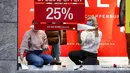 Pekerja memasang iklan penawaran khusus untuk dua hari ke depan di jendela toko di pusat Kota Essen, Jerman, Senin (14/12/2020). Jerman melakukan lockdown nasional pada 16 Desember 2020 untuk memerangi pandemi COVID-19. (AP Photo/Martin Meissner)