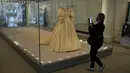 <p>Jurnalis berdiri di samping gaun pengantin Putri Diana selama pratinjau media untuk pameran "Royal Style in the Making" di Istana Kensington di London, Rabu (2/6/2021). Pameran yang dibuka untuk pengunjung pada Kamis, 3 Juni 2021, ini akan berlangsung hingga 2 Januari 2022. (AP Photo/Matt Dunham)</p>
