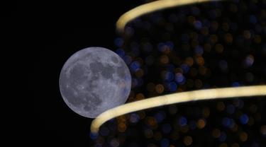 Bulan purnama terbit di atas Bagdad, Irak, pada Rabu (13/7/2022). Bulan Purnama dikenal sebagai Buck Moon dan juga Supermoon. Di kondisi ini Bulan akan terlihat tampak lebih besar dan terang sehingga terasa sangat dekat dari Bumi. (AP Photo/Hadi Mizban)