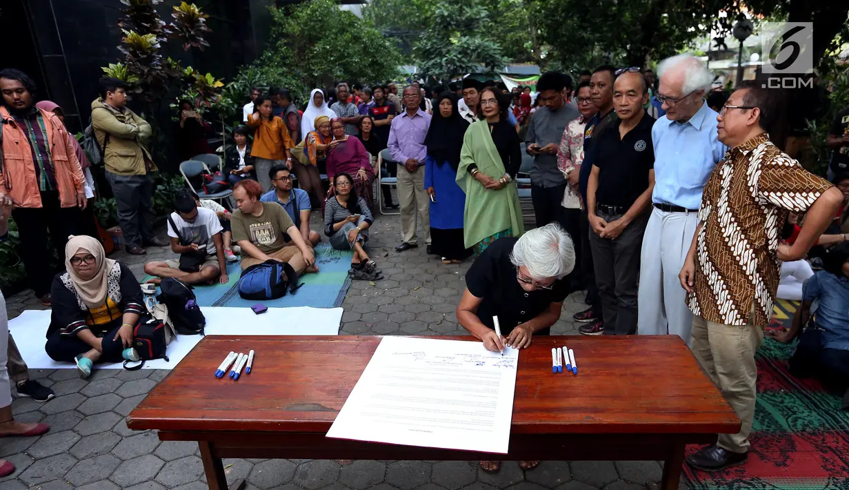 Ibu korban tragedi Mei 1998, Sumarsih membubuhkan tanda tangan saat Deklarasi "LBH Rumah Kita" di pelataran LBH, Jakarta, Senin (25/9). Pasca penyerangan, LBH membuka kantor dan gedung serta layanan Bantuan Hukumnya. (Liputan6.com/JohanTallo)