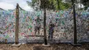 Aktivis Ecological Observation and Wetland Conservation (Ecoton) membuat instalasi yang terbuat dari sampah plastik di Gresik, Jawa Timur, 17 September 2021. Instalasi tersebut di antaranya terbuat dari 4.444 botol. (JUNI KRISWANTO/AFP)