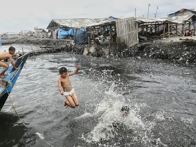 Anak-anak bermain air di kawasan pantai penuh sampah yang terbawa arus di Muara Angke, Jakarta, Rabu (10/2). Genangan sampah yang terbawa arus oleh angin musim barat ini tak menyurutkan anak-anak untuk bermain air. (Liputan6.com/Faizal Fanani)