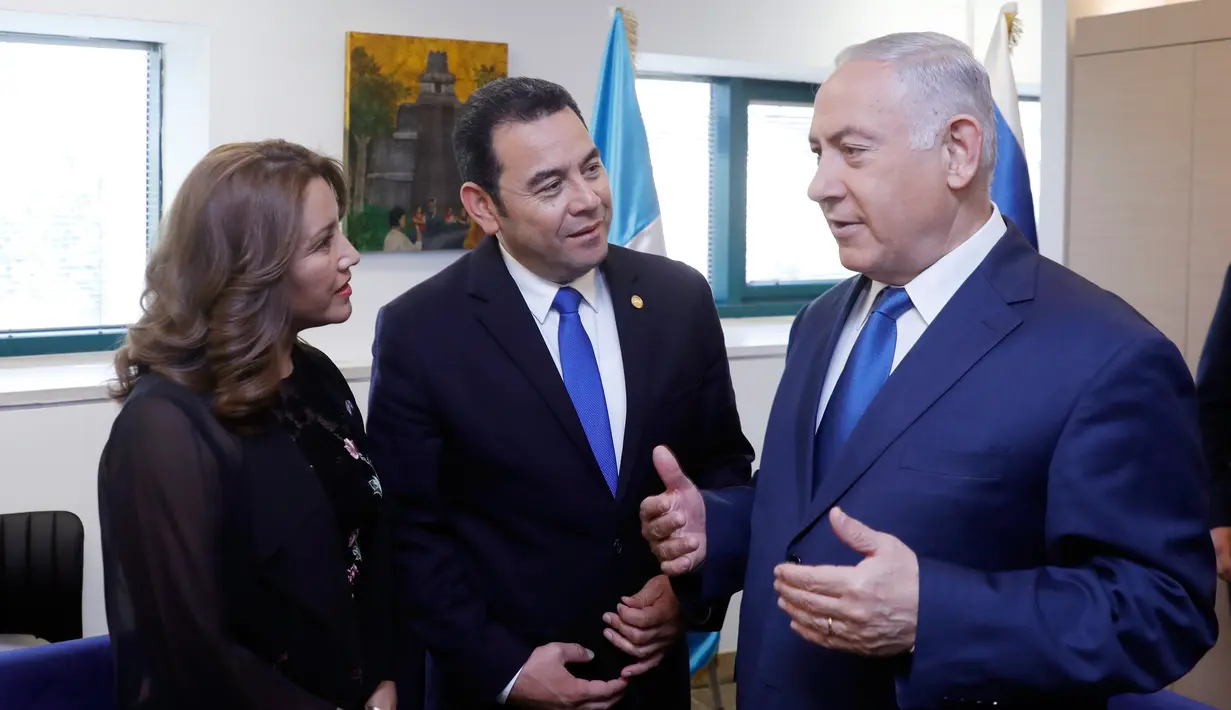 Presiden Guatemala Jimmy Morales dan istri, Hilda Patricia Marroquin, berbicara dengan PM Israel Benjamin Netanyahu sebelum upacara peresmian Kedutaan Besar Guatemala di Yerusalem, Rabu (16/5). (Ronen Zvulun/Pool via AP)
