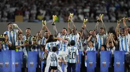 Lionel Messi memimpin momen mengangkat trofi Piala Dunia 2022 di tengah lapangan bersama seluruh penggawa La Albiceleste diikuti dengan keluarga setiap pemain yang turut hadir di lapangan. (AP Photo/Natacha Pisarenko)