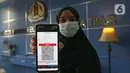 Pemohon paspor menunjukkan nomor antrian melalui aplikasi di kantor  Imigrasi kelas 1 TPI Jakarta Timur, Jumat (11/06/2021) Pemohon yang ingin mengajukan permohonan paspor atau penggantian di batasi 25 persen, yang harus dilakukan masih sama seperti sebelum Covid-19. (Liputan6.com/Herman Zakharia)