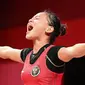 Reaksi lifter putri Indonesia Windy Cantika Aisah usai bertanding dalam cabang angkat besi nomor 49 kg Putri Grup A Olimpiade Tokyo 2020 di Tokyo International Forum, Sabtu (24/7/2021). Windy Cantika mempersembahkan medali perunggu dengan total angkatan 194 Kg. (Vincenzo PINTO/AFP)