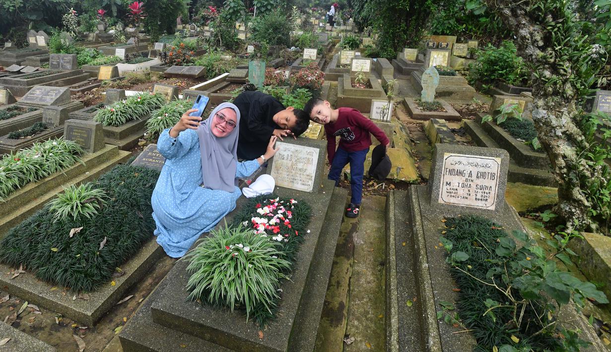 Warga saat berziarah di makam keluarganya di Tempat Pemakaman Umum (TPU) Dreded, Bogor, Jawa Barat, Minggu (15/2/2026). (merdeka.com/Arie Basuki)