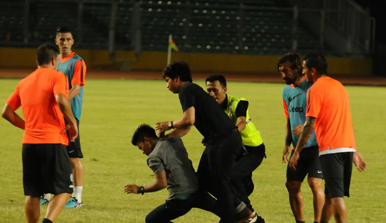 Pihak keamanan mendorong suporter yang lolos masuk ke areal lapangan dan memeluk gelandang Juventus, Andrea Pirlo, di Stadion GBK, Jakarta, (5/8/2014). (Liputan6.com/Helmi Fithriansyah)