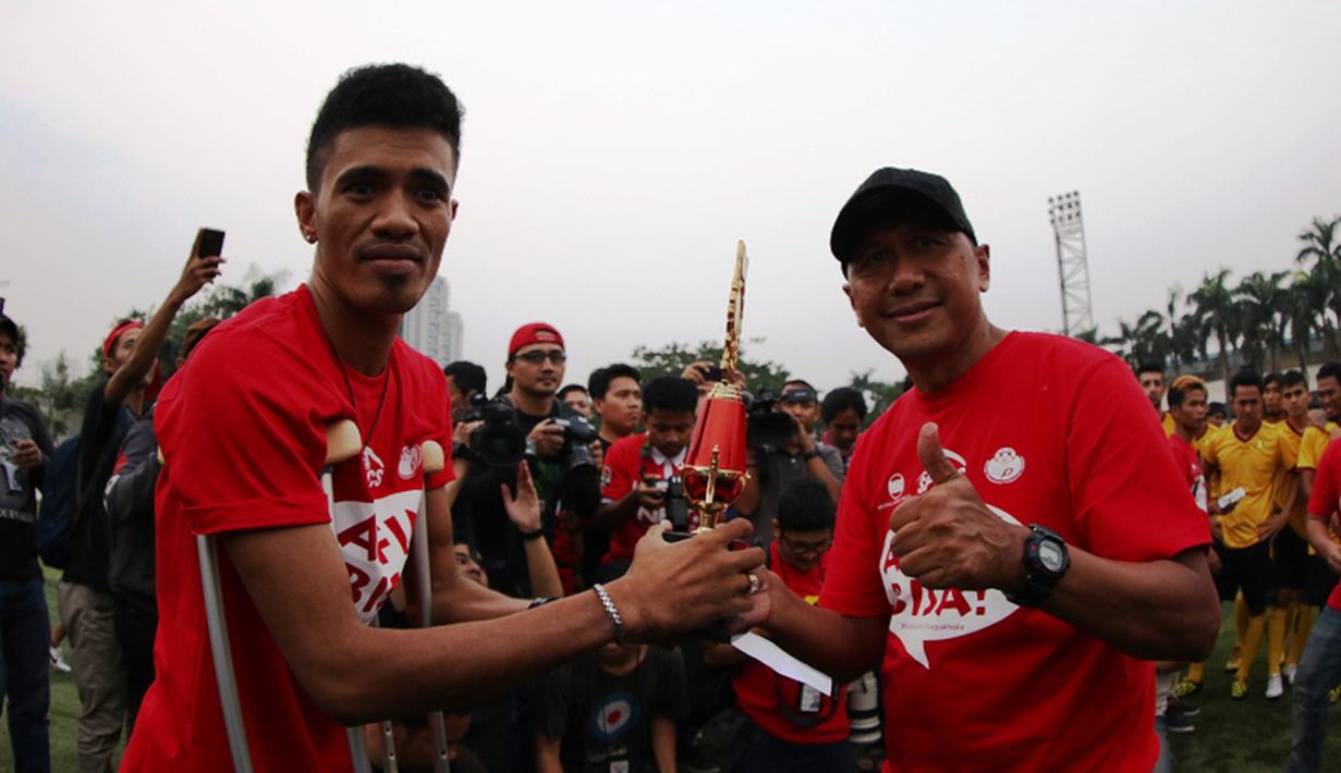 Alfin Tuasalamony menerima piala dari rekan-rekan pesepakbola yang diserahkan Rahmad Darmawan. (Bola.com/Arief Bagus)
