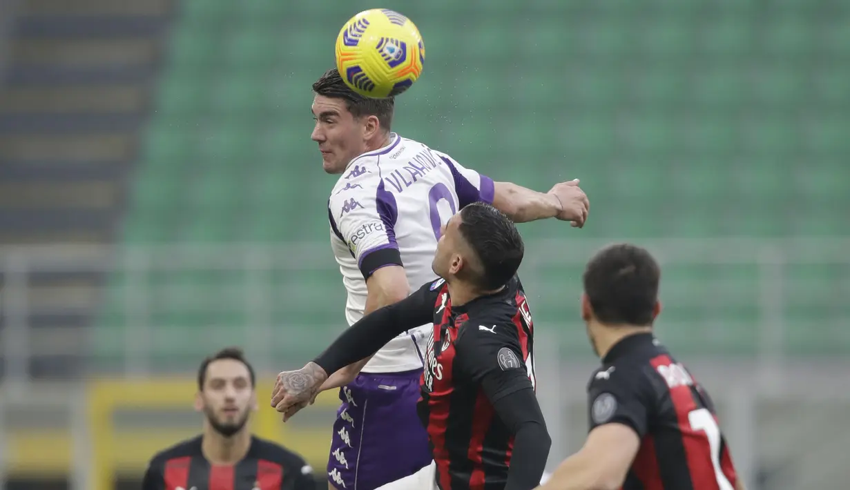 Gelandang Fiorentina,  Dusan Vlahovic berebut bola udara dengan bek AC Milan, Theo Hernandez pada pertandingan lanjutan Liga Serie A Italia di stadion San Siro di Milan, Italia, Minggu (29/11/2020). AC Milan menang 2-0 atas Fiorentina. (AP Photo / Luca Bruno )