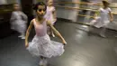 Gadis-gadis kecil mengikuti kelas balet di sebuah studio di Moskow , 22 November 2018. Orang tua dan kakek-nenek duduk di koridor sebuah studio kecil di Moskow utara menunggu anak-anak usia tiga tahun menyelesaikan kelas balet mereka. (Mladen ANTONOV/AFP)