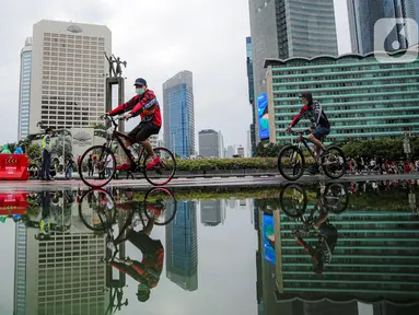 Warga bersepeda saat Car Free Day (CFD) di kawasan Bundaran HI, Jakarta, Minggu (2/10/2022). Meski diguyur hujan deras sejak pagi, warga tetap antusias untuk tetap berolahraga saat CFD. (Liputan6.com/Faizal Fanani)