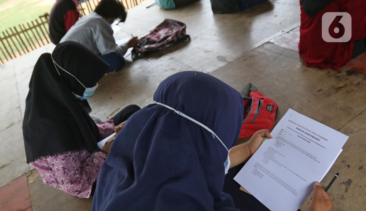 Seorang murid SMP Sekolah Alam melihat soal Ujian Akhir Semester (UAS) di Sukawangi, Kabuapaten Bekasi, Jawa Barat, Senin (30/11/2020). Menurut pengurus Sekolah Alam KBM tatap muka  jenjang pendidikan SD,SMP, dan SMA tetap berjalan dengan menerapkan protokol kesehatan. (Liputan6.com/Herman Zakharia)