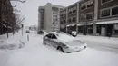 Sebuah mobil terkubur dalam salju selama badai salju di lingkungan East Village di Des Moines, Iowa, pada tanggal 12 Januari 2024. (Christian MONTERROSA/AFP)