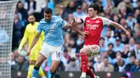 Pemain Manchester City, Rodri, berebut bola dengan pemain Arsenal, Declan Rice, dalam pertandingan Liga Inggris di Etihad, Inggris, Minggu (19/4/2026) malam WIB. (AP Photo/Dave Thompson)