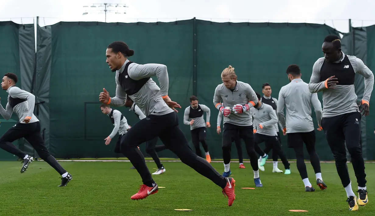 Para pemain Liverpool melakukan pemanasan selama latihan di Melwood Training Ground di Liverpool, Inggris (3/4). Liverpool akan bertanding melawan klub senegaranya Manchester City pada leg pertama babak perempatfinal Liga Champions. (AFP Photo/Paul Ellis)