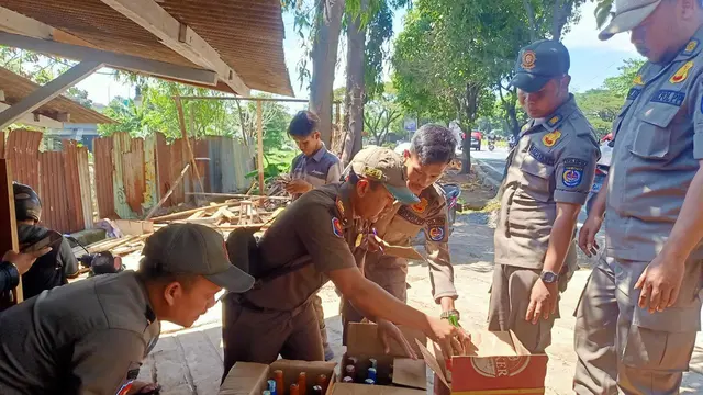 Anggota Satpol PP Kota Depok menyita puluhan botol miras dari sebuah warung di Jalan Raya Juanda, Sukmajaya, Depok.