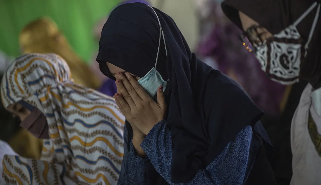Berda Asmara (tengah), istri dari Serda Mes Guntur Ari Prasetya, berdoa bersama para dosen di Universitas Nahdlatul Ulama Surabaya, Jawa Timur, Senin (26/4/2021). Sholat ghaib dan doa bersama tersebut untuk mendoakan seluruh kru KRI Nanggala 402 yang tenggelam di perairan Bali (Juni Kriswanto/AFP)