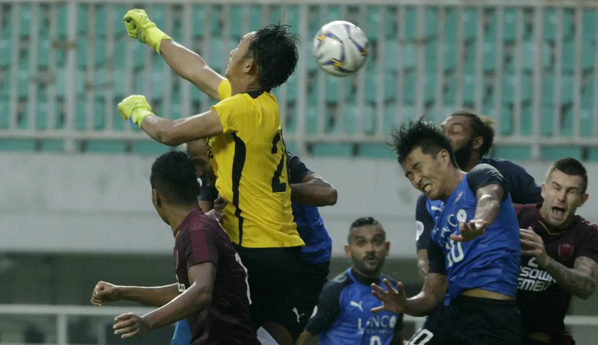 Kiper PSM Makassar, Rivky Mokodompit, menghalau bola saat melawan Home United pada laga Piala AFC 2019 di Stadion Pakansari, Jawa Barat, Selasa (30/4). PSM menang 3-2 atas Home United. (Bola.com/M Iqbal Ichsan)