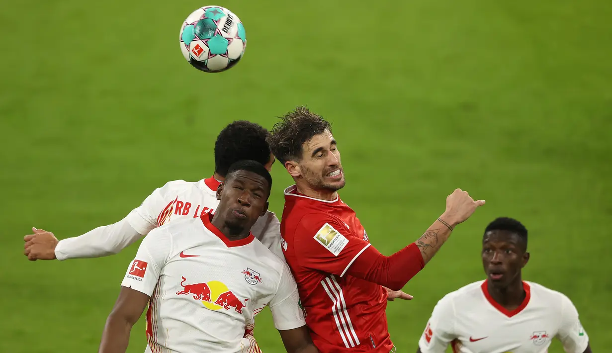 Bek RB Leipzig, Nordi Mukiele (kiri), berduel udara dengan gelandang Bayern Munich, Javier Martinez (tengah), dalam laga lanjutan Liga Jerman pekan ke-10 di Allianz Arena, Sabtu (5/12/2020). RB Leipzig bermain imbang 3-3 dengan Bayern Munich. (AFP/Alexander Hassenstein/Pool)