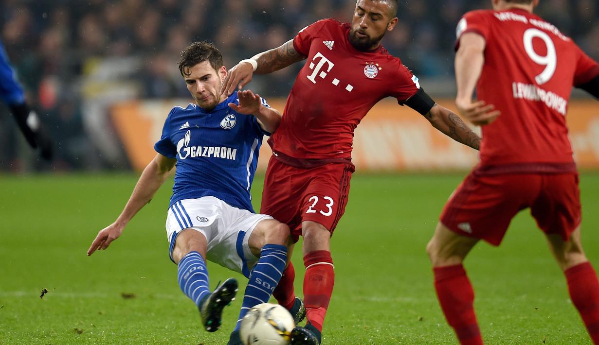 Pemain Bayern Munich, Arturo Vidal (tengah) berebut bola dengan pemain Schalke 04, Leon Goretzka pada lanjutan Bundesliga di Gelsenkirchen, Jerman,Minggu (22/11/2015) dini hari WIB. Bayern Munich  menang 3-1. (AFP Photo/Patrik Stollarz)