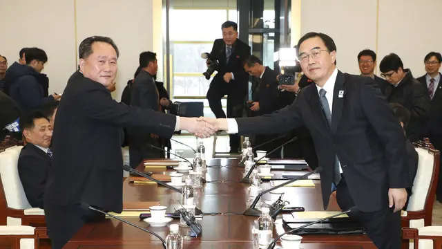 Menteri Unifikasi Korea Selatan Cho Myoung-gyon (kanan) berjabat tangan dengan Ketua Komite Reunifikasi Damai Korea Utara Ri Son Gwon dalam pertemuan di DMZ. (Korea Pool/Yonhap via AP)