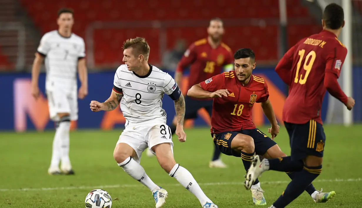 Gelandang Jerman Toni Kroos membawa bola dari kawalan gelandang Spanyol Oscar Rodriguez pada pertandingan UEFA Nations League di Stuttgart, Jerman (3/9/2020). Jerman bermain imbang 1-1 atas Spanyol. (AFP Photo/Thomas Kienzle)