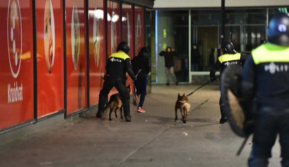 Polisi mengerahkan anjing pelacak untuk membubarkan aksi protes yang digelar oleh warga Turki di Rotterdam, Belanda (11/3). Aksi protes dilancarkan setelah Pemerintah Belanda melarang Menteri Luar Negeri Turki mendarat di Belanda. (AFP/Emmanuel Dunand)