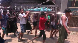 Sejumlah warga membawa mayat warga minoritas Muslim Rohingya yang tewas setelah perahu yang mereka tumpangi tenggelam di lepas pantai Negara Bagian Rakhine, Myanmar, Selasa (19/4). Sedikitnya 21 orang termasuk sembilan anak tewas. (STR/AFP)