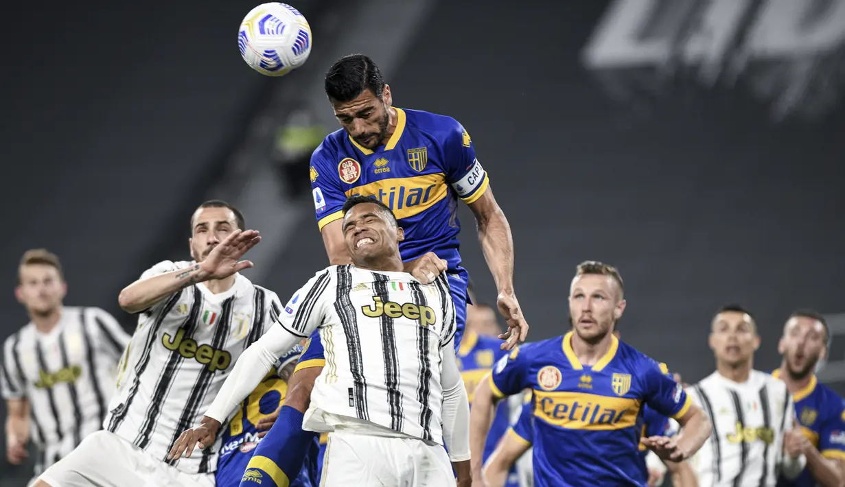 Pemain Juventus Alex Sandro (tengah) melompat untuk merebut bola dengan pemain Parma Graziano Pelle (atas) pada pertandingan Serie A di Stadion Allianz Turin, Italia, Rabu (21/4/2021). Juventus menang 3-1. (Piero Cruciatti/LaPresse via AP)