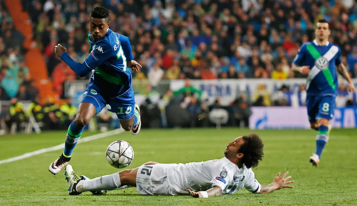 Bek Real Madrid, Marcelo (kanan) berusaha menghalau bola yang dibawa penyerang Wolfsburg, Bruno Henrique di leg kedua liga Champions di Santiago Bernabeu, Spanyol (13/4). Madrid menang atas Wolfsburg dengan skor 3-0. (Reuters/Sergio Perez)