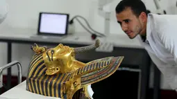 Petugas Museum saat melihat topeng emas Raja Tutankhamun di museum Mesir, Kairo, Selasa (20/10/2015). Para Kolektor dan ilmuwan benda bersejarah sedang melakukan restorasi terhadap topeng emas Raja Tutankhamun. (REUTERS/Mohamed Abd El Ghany)