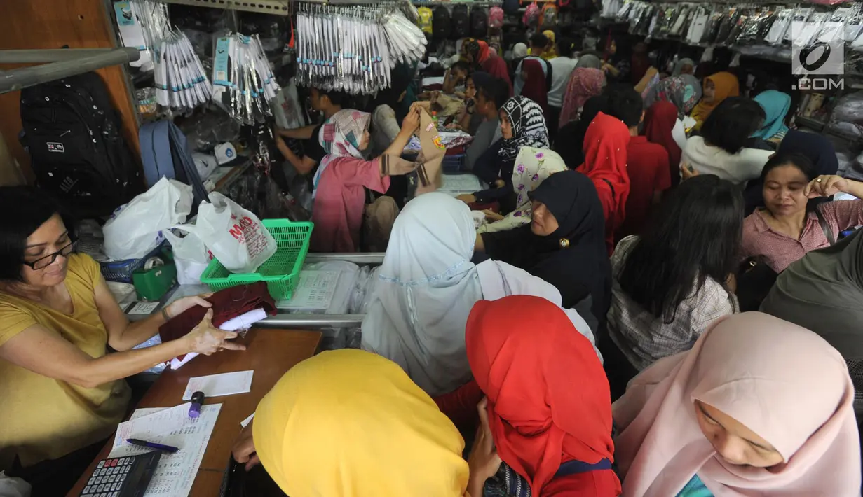 Sejumlah pembeli memilih baju seragam sekolah baru untuk anaknya di salah satu kios di Jalan Pengadilan, Bogor, Rabu (11/7). Menjelang dimulainya tahun ajaran baru, para orang tua disibukan belanja kelengkapan sekolah anak mereka (Merdeka.com/Arie Basuki)