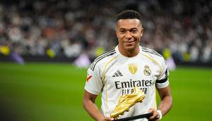 Pemain Real Madrid, Kylian Mbappe, berpose dengan trofi Sepatu Emas sebelum pertandingan La Liga Spanyol&nbsp;melawan Valencia di Santiago Bernabeu, Spanyol, Sabtu (1/11/2025). (AP Photo/Manu Fernandez)