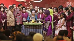 Pendiri PT Mustika Ratu Tbk, Mooryati Soedibyo (tengah) memotong tumpeng saat perayaan ulang tahunnya yang ke 90 di kawasan Gatot Subroto, Jakarta, Jumat (5/1). (Liputan6.com/Herman Zakharia)