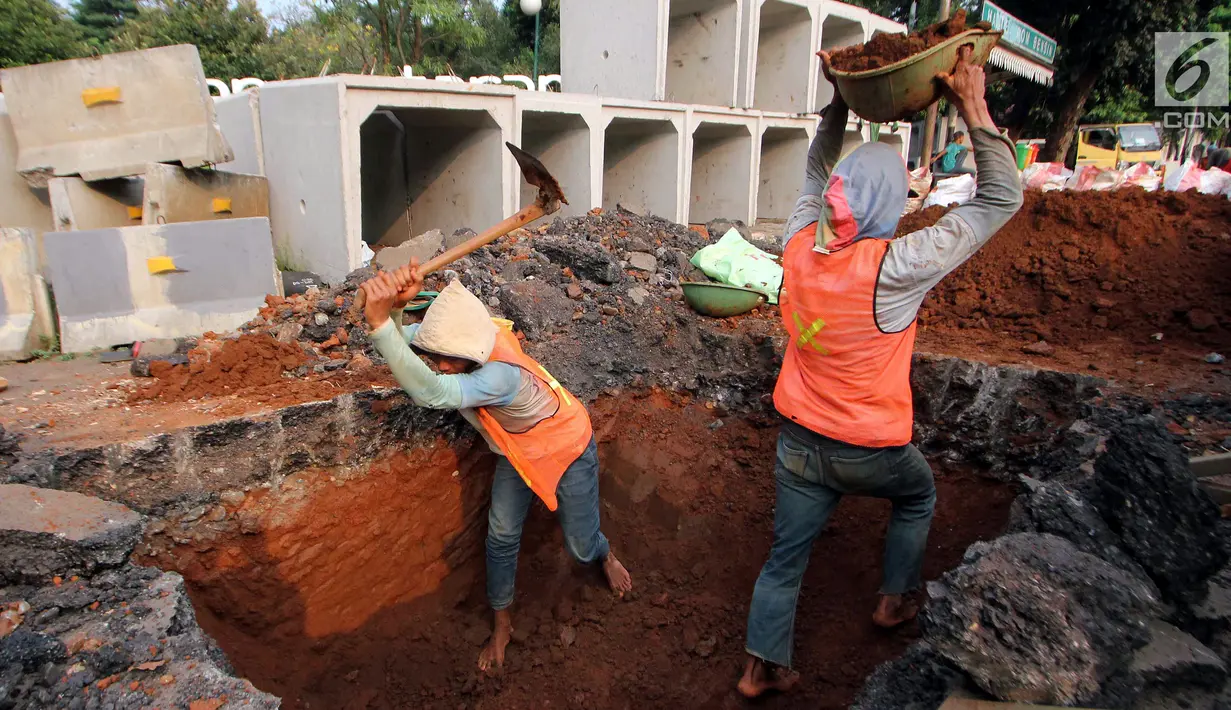 Pekerja menggali lubang untuk pengerjaan penataan jalur pedestrian di Jalan Sisingamangaraja, Jakarta Selatan, Jumat (4/5). Perbaikan tersebut untuk memperlancar aliran air saat musim penghujan tiba. (Liputan6.com/JohanTallo)