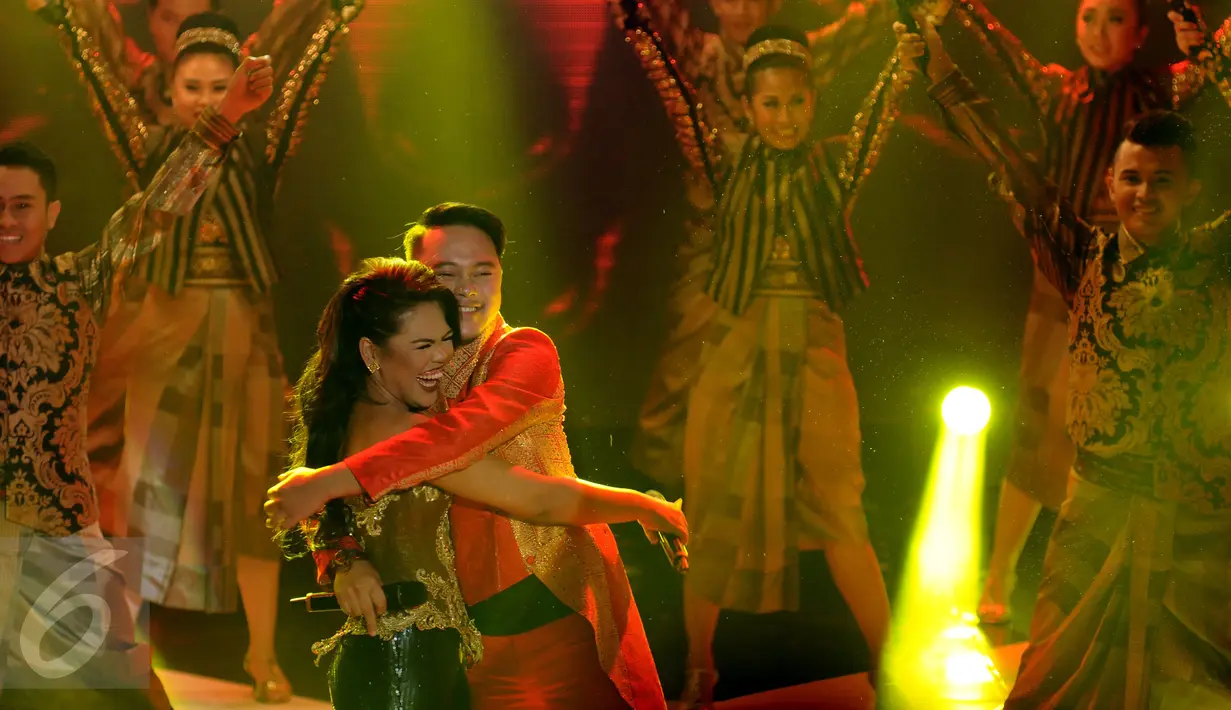 Weni (kiri) dipeluk Danang usai tampil di konser kemenangan D'Academy Asia 2 di Studio 5 Indosiar, Jakarta, Kamis (29/12). Weni berhasil tampil menjadi juara dan Rani harus puas diposisi kedua serta Irsya ditempat ketiga. (Liputan6.com/Helmi Fithriansyah)